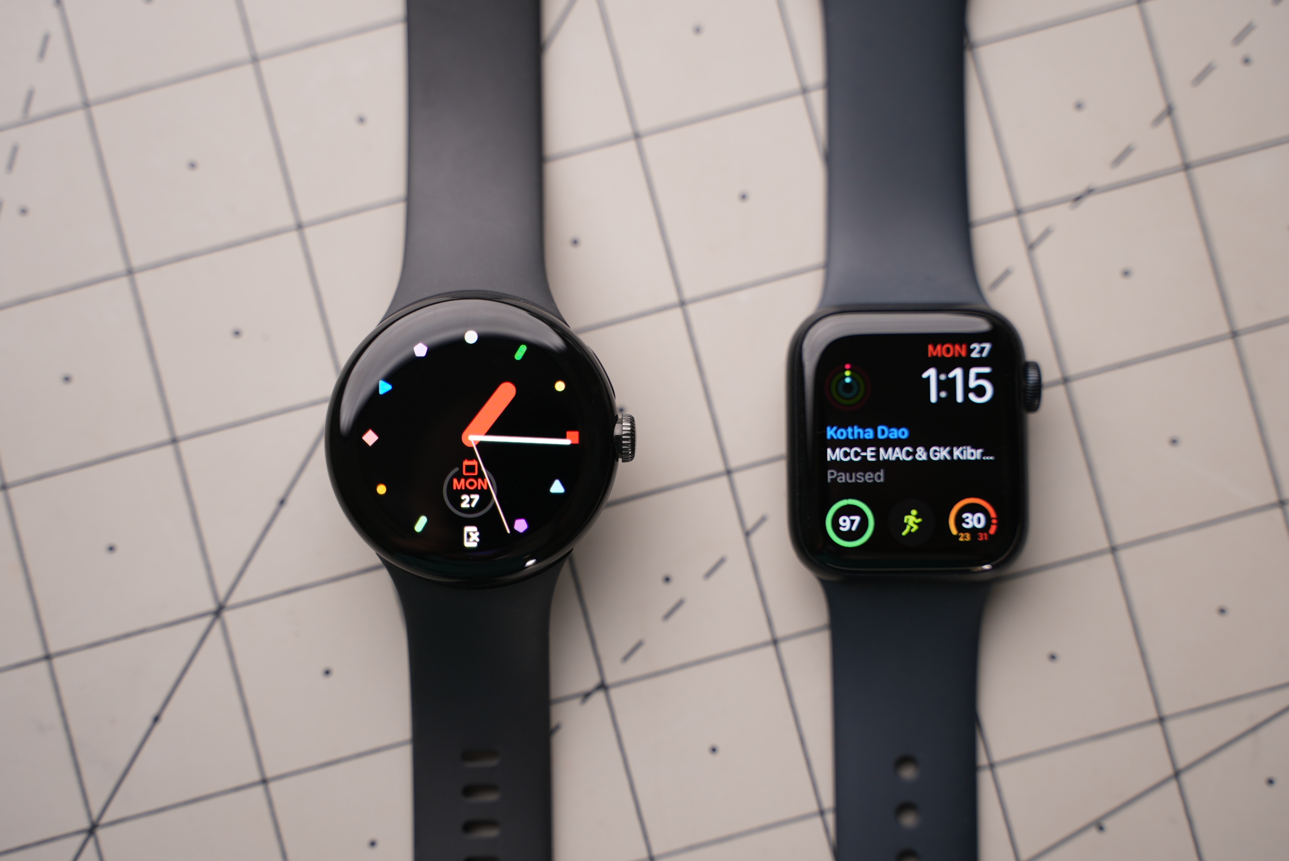 Google Pixel Watch and Apple Watch laying next to each other