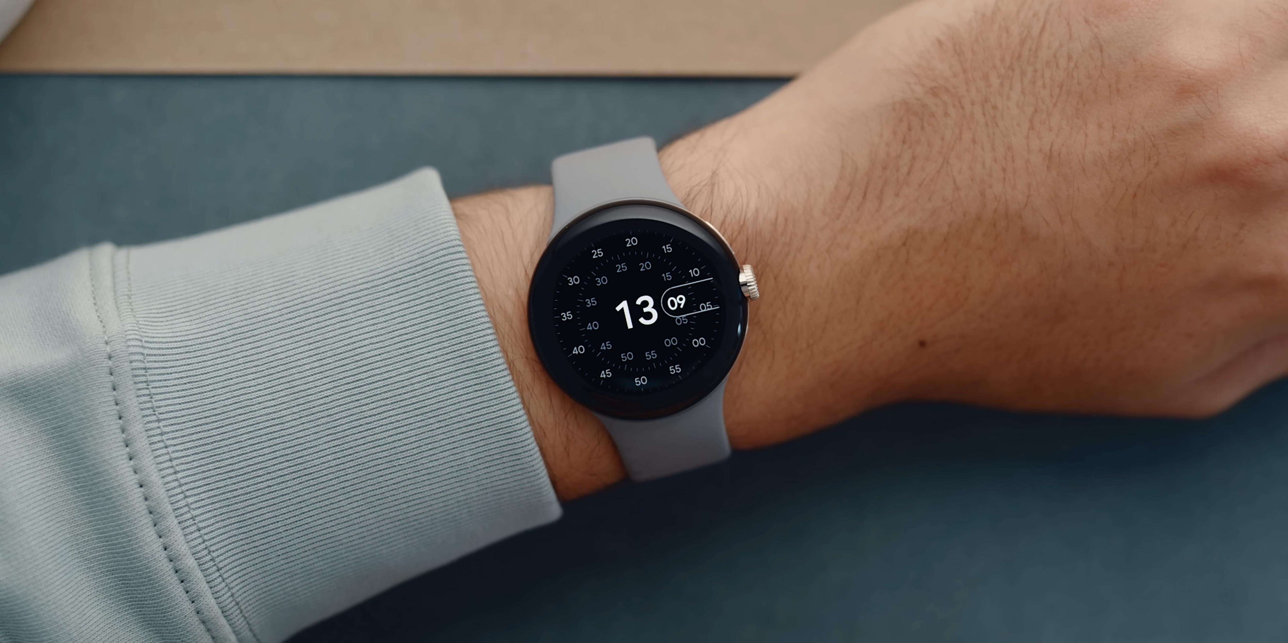 Google Pixel Watch with a gray band on someone's wrist