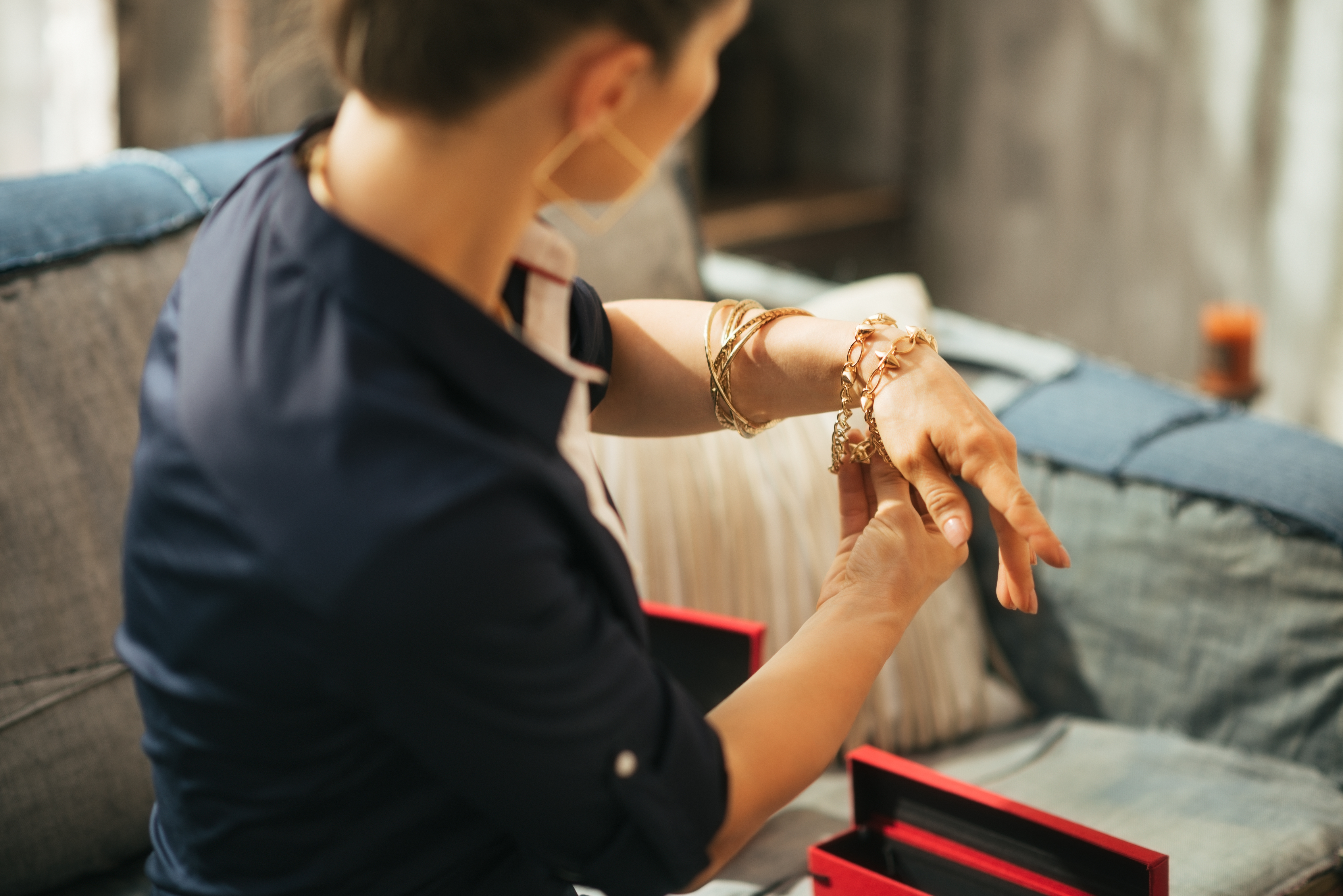 Woman looking at different bracelets on her wrist