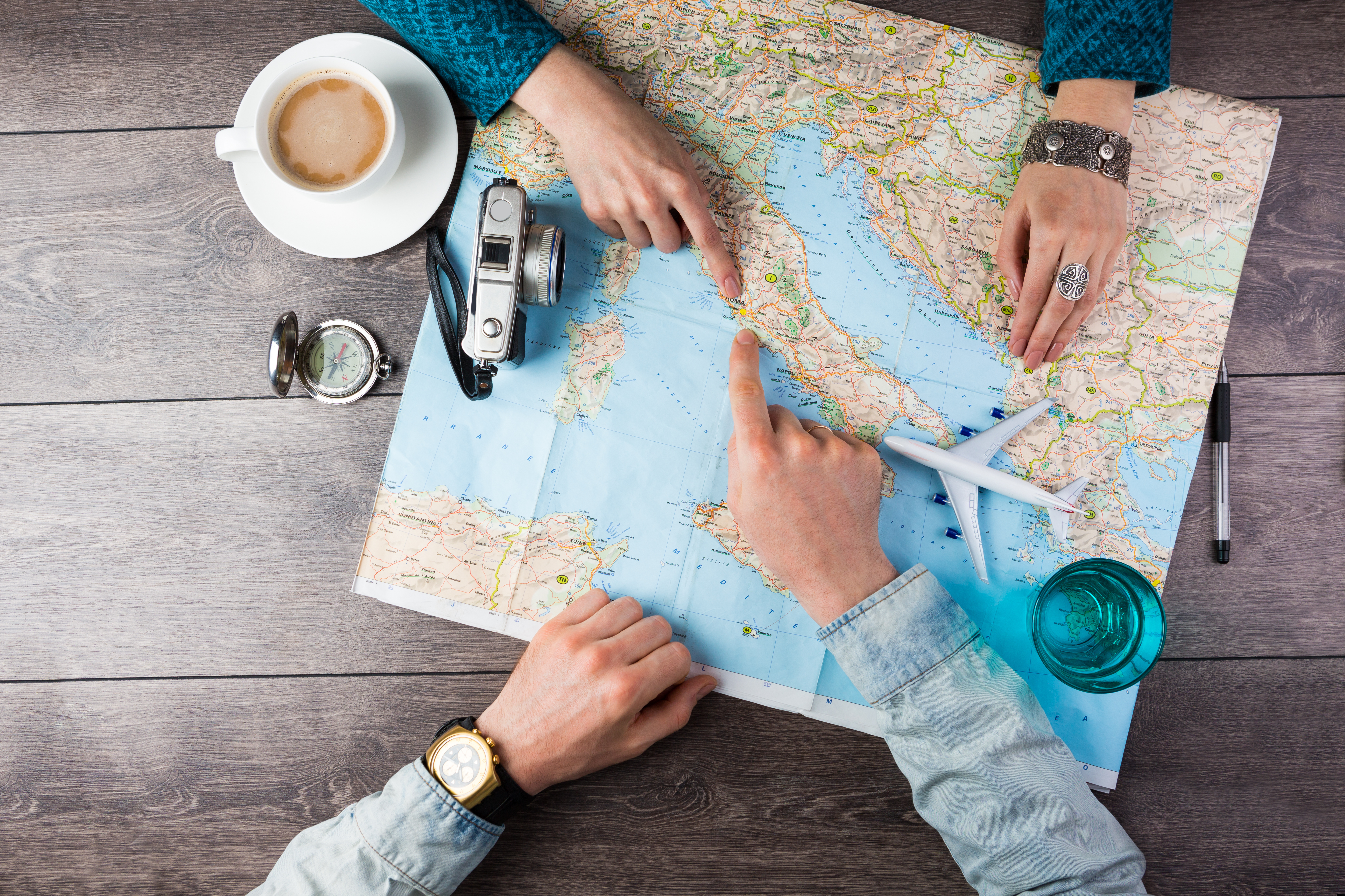 Man and a woman pointing at countries on a map