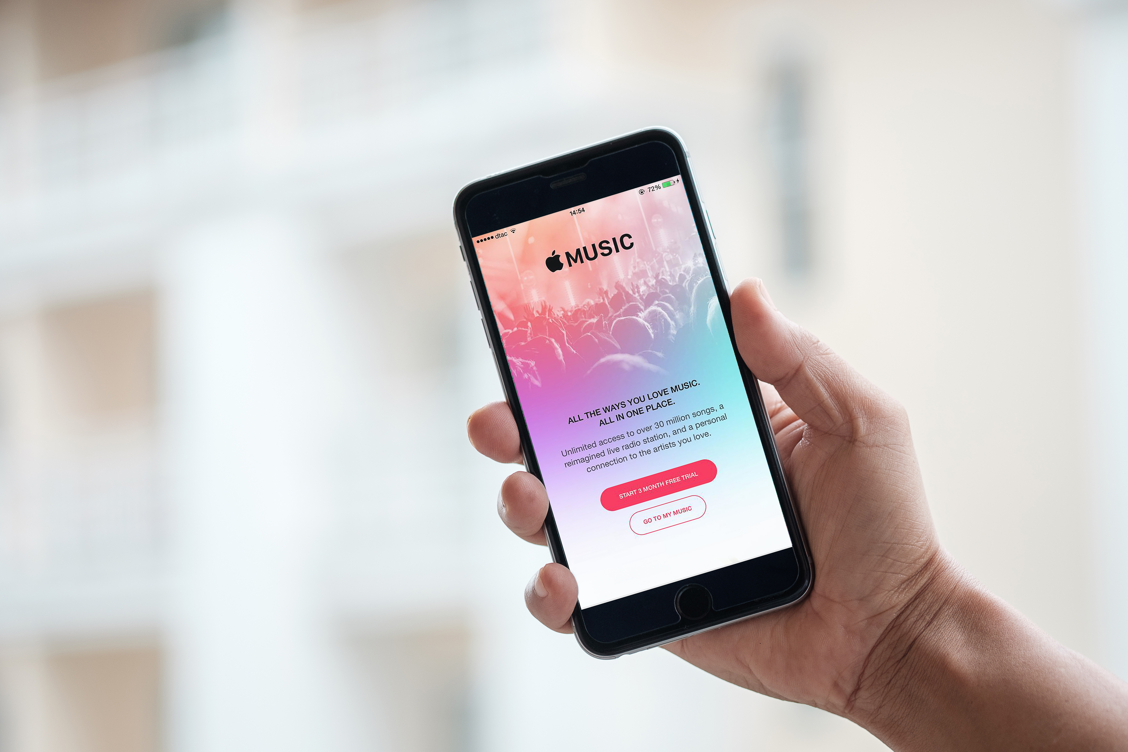 Person holding a smartphone with the Apple Music login page on it