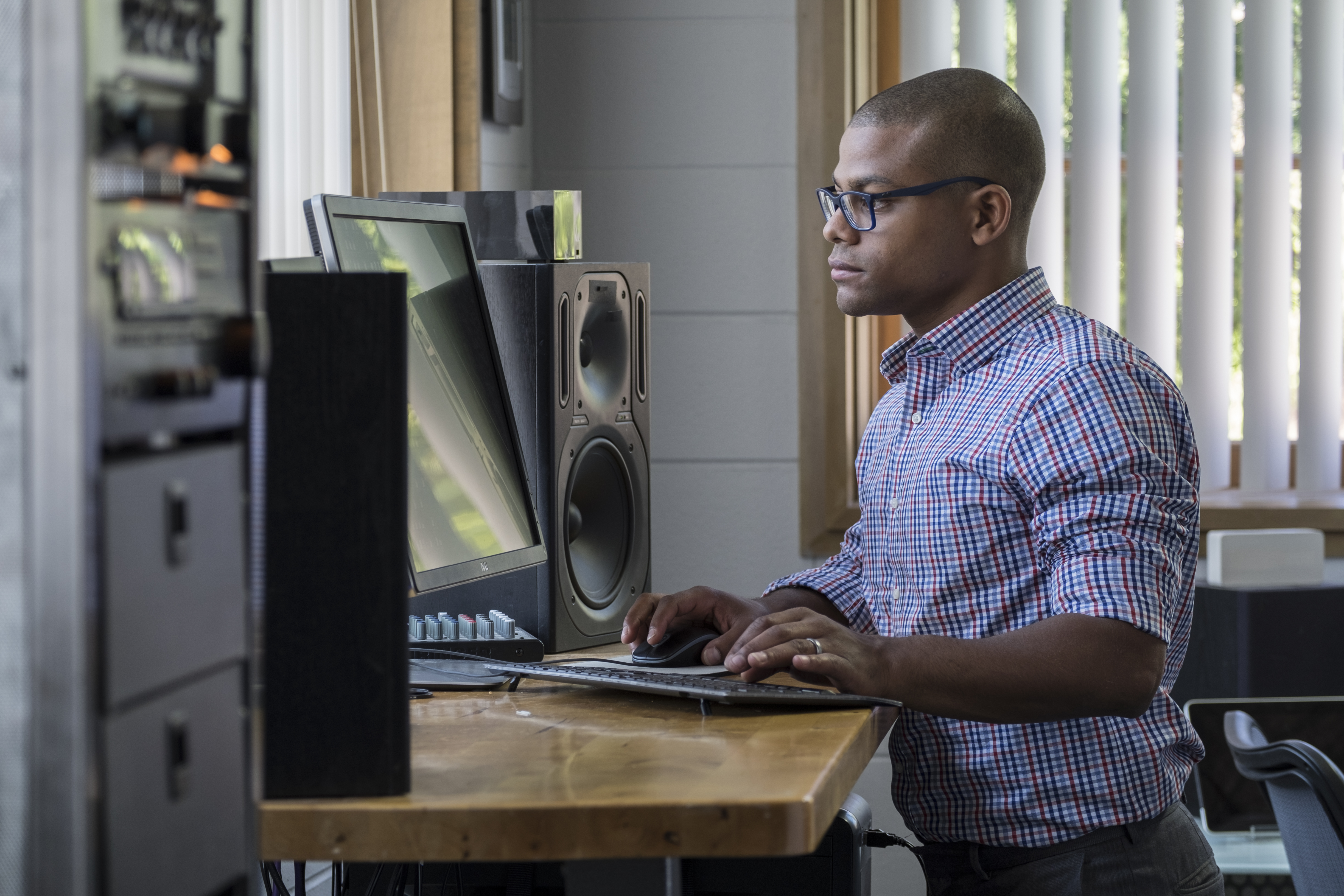 Man wearing glasses standing at a standing desk