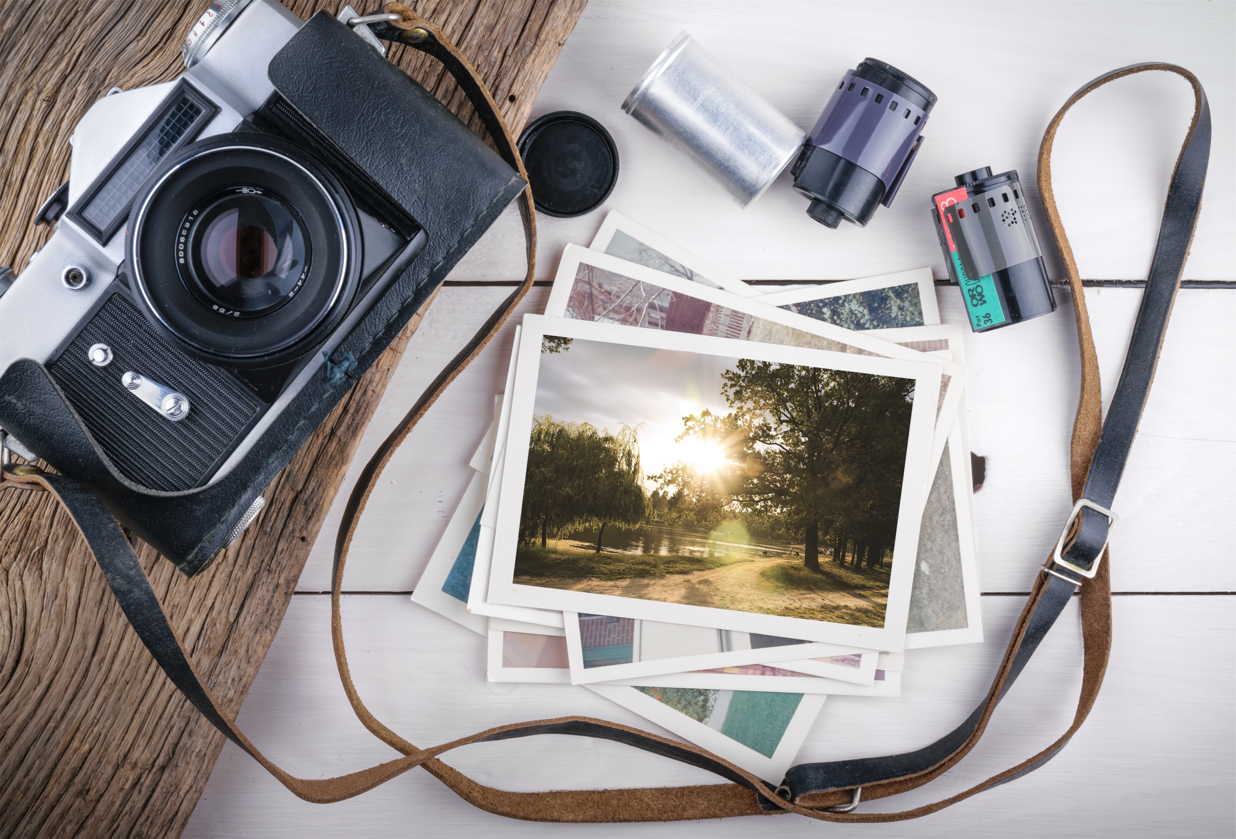 Film camera with photos and rolls of film sitting on a table