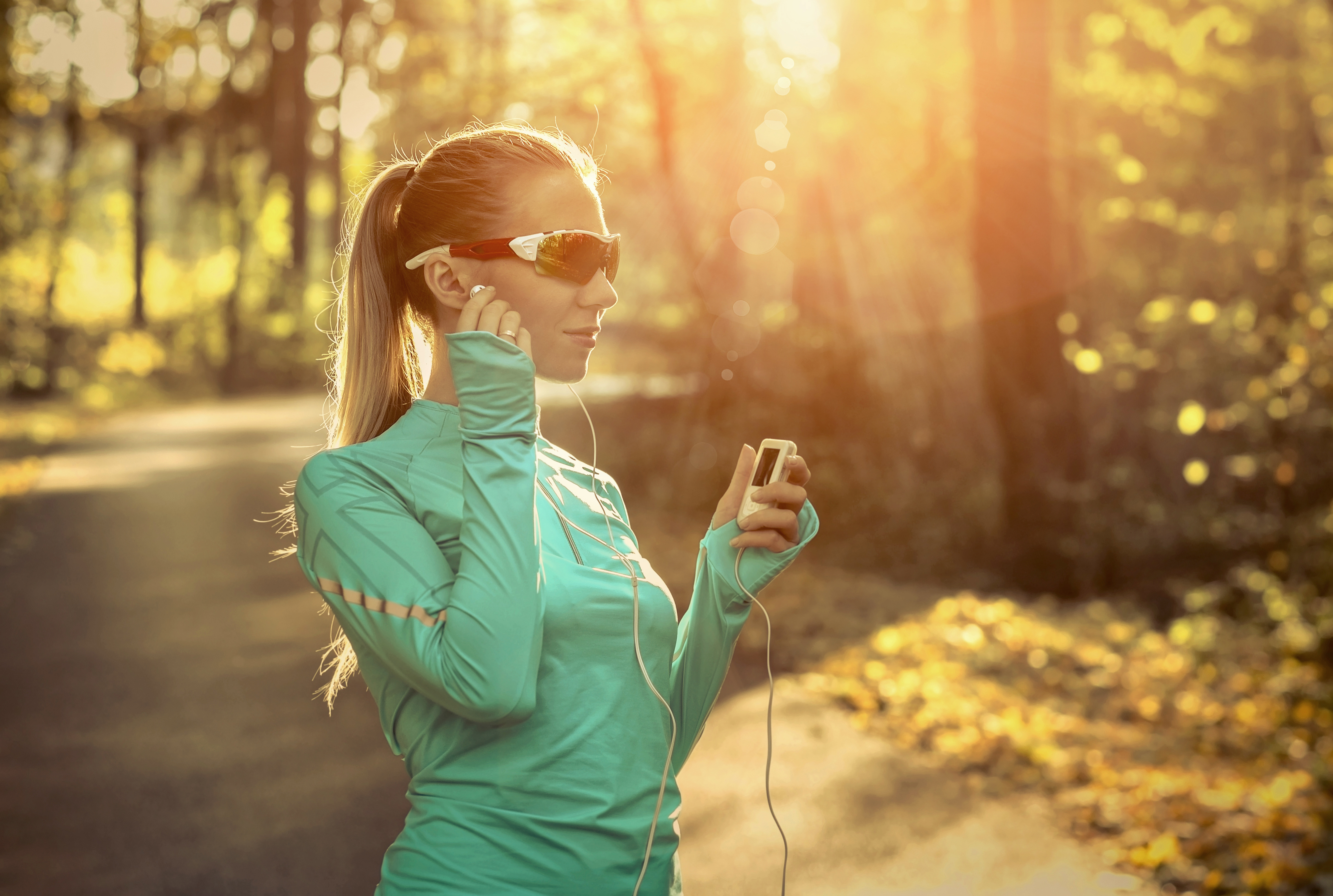 Woman outdoors with headphones in wearing sport sunglasses