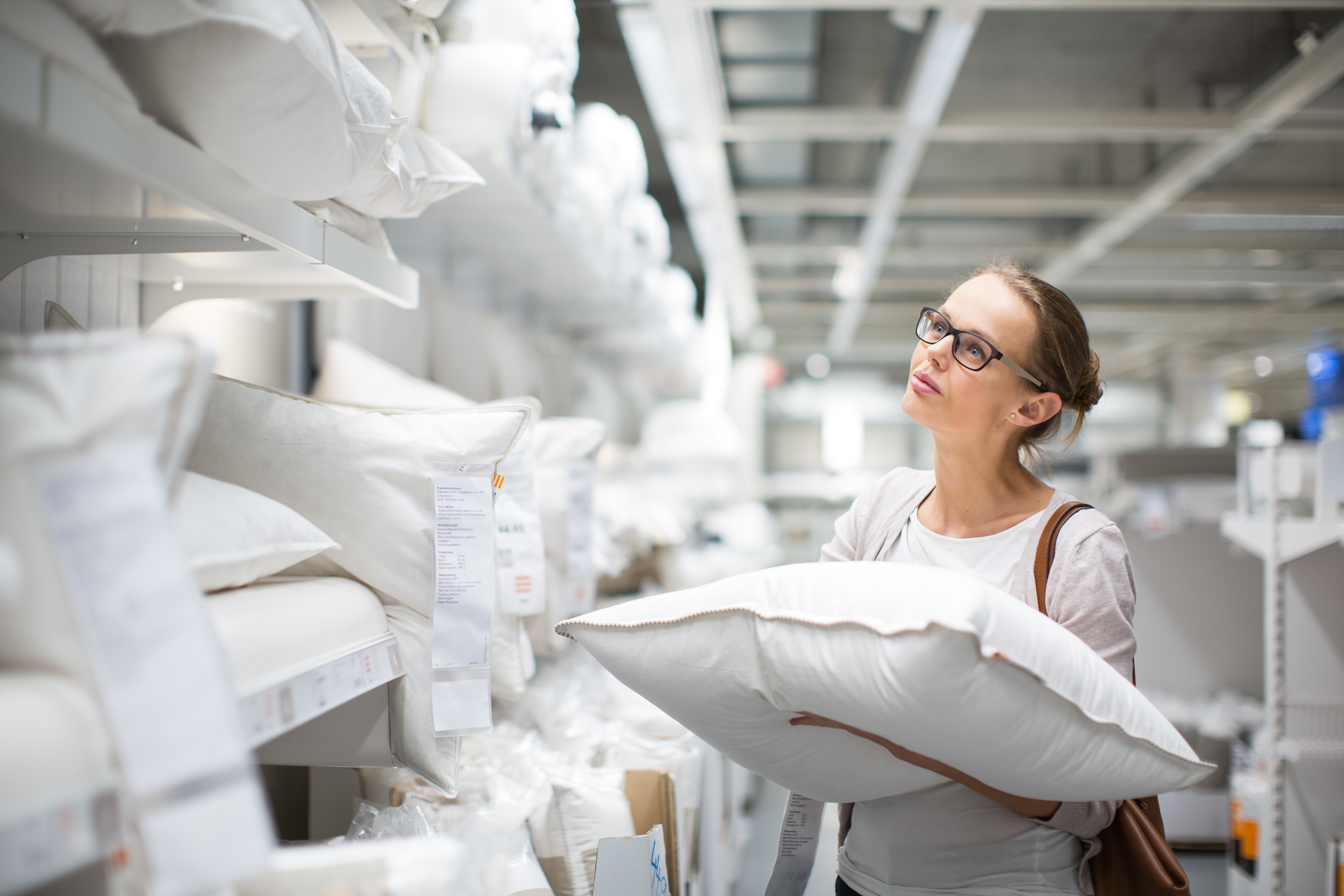 Woman wearing glasses shopping for pillows