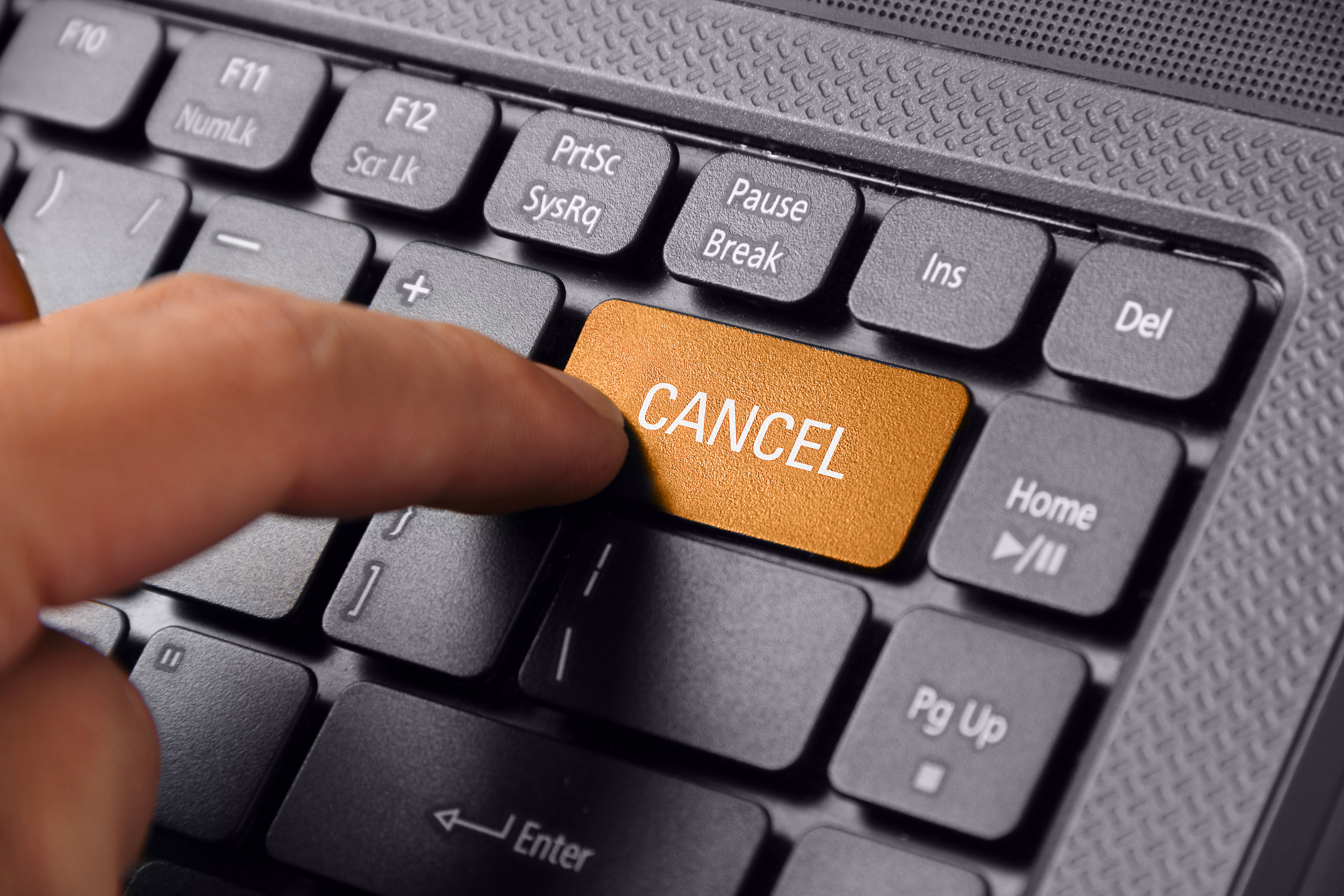 Person pressing the cancel button on a keyboard