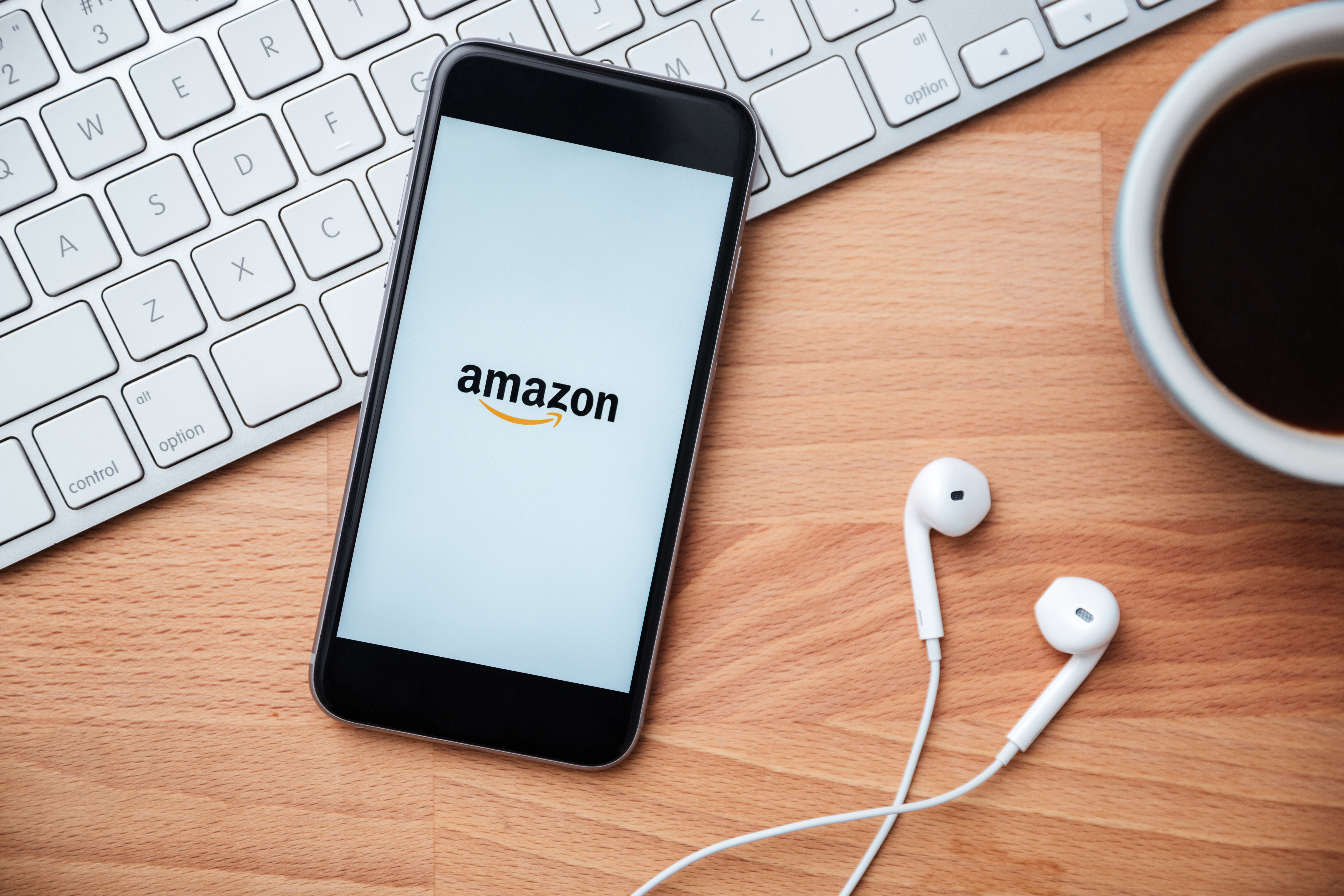 Smartphone sitting on a desk with the Amazon logo on it