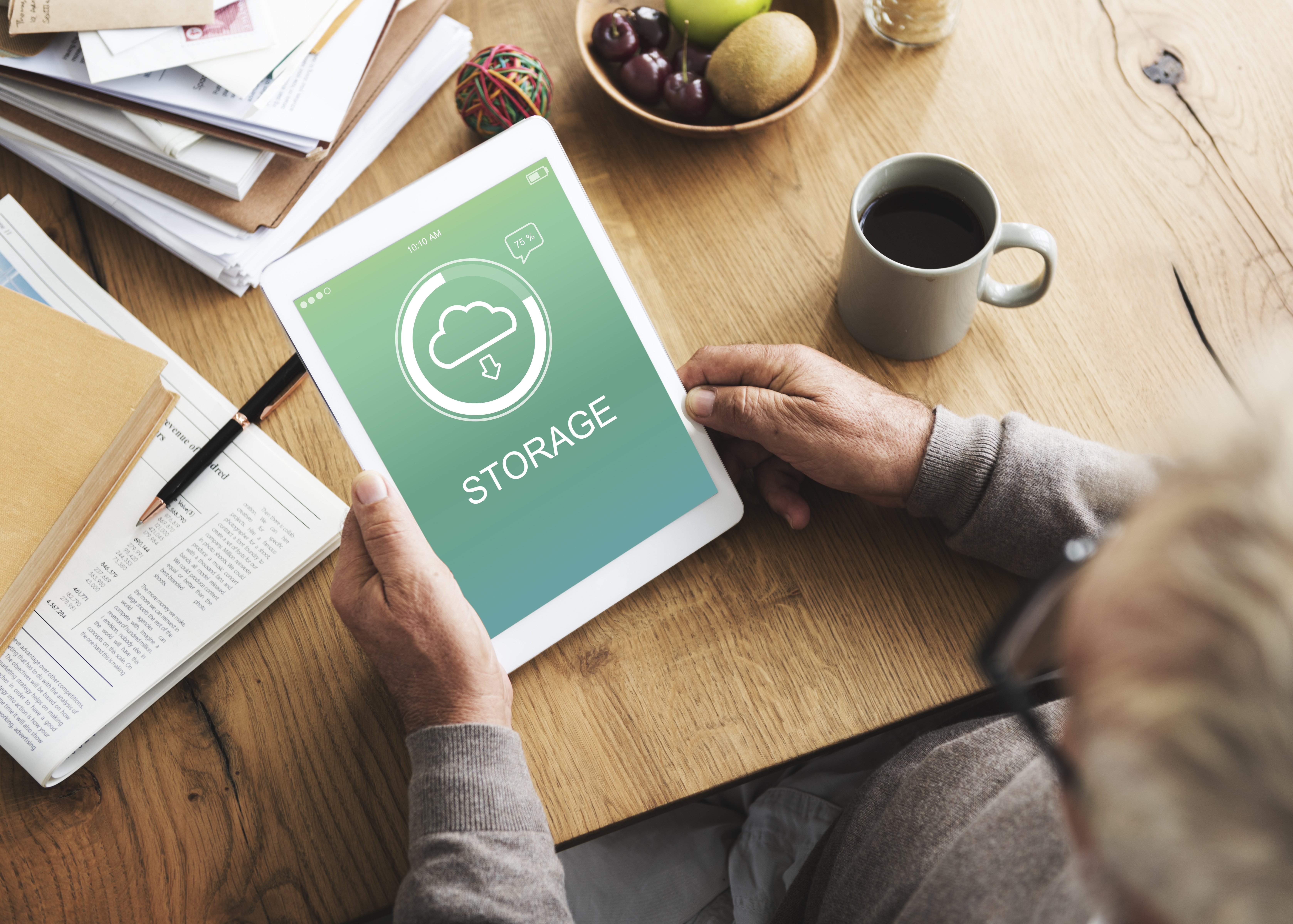 Man holding a tablet with a cloud storage icon on it