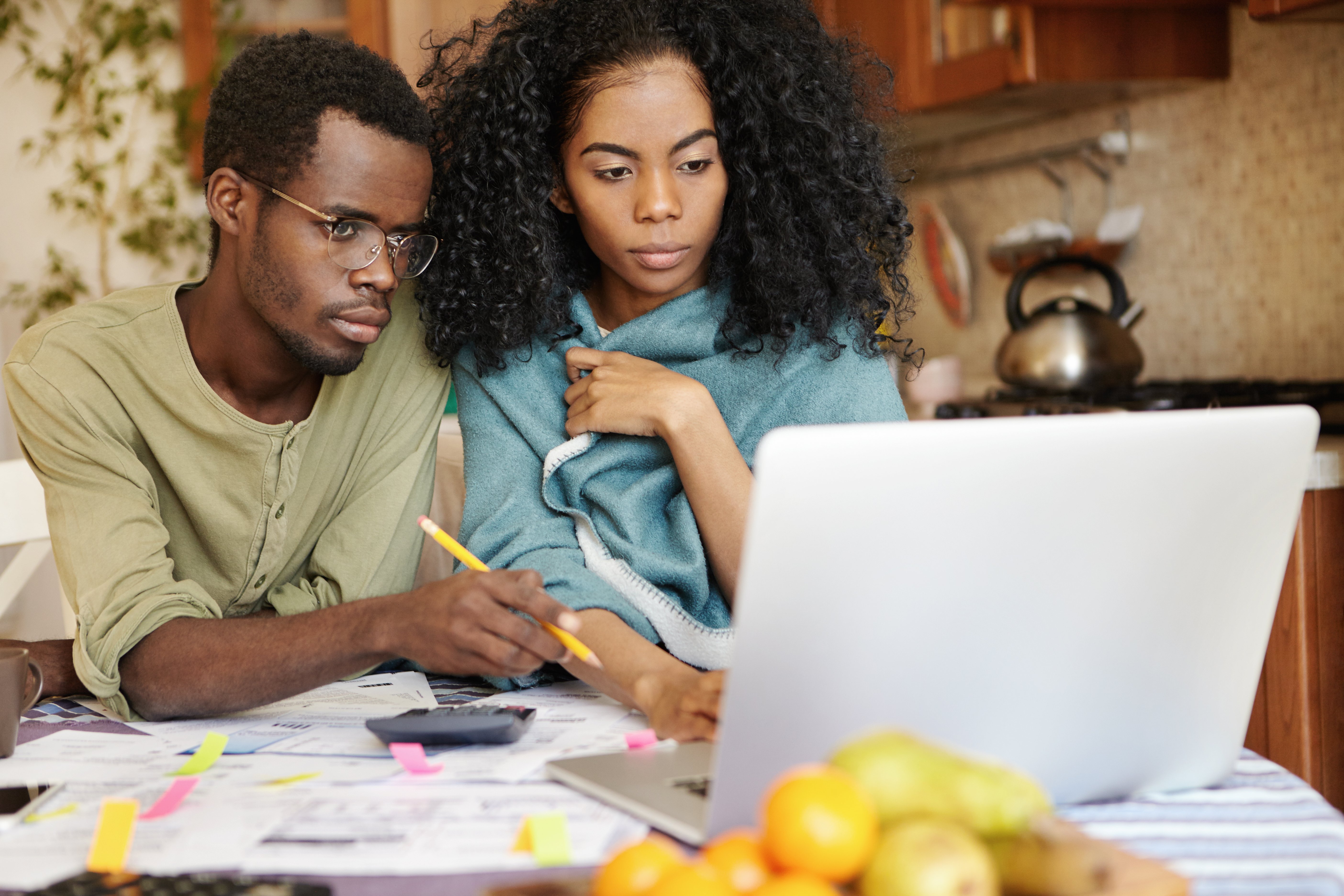 Man and woman looking over their finances on a laptop
