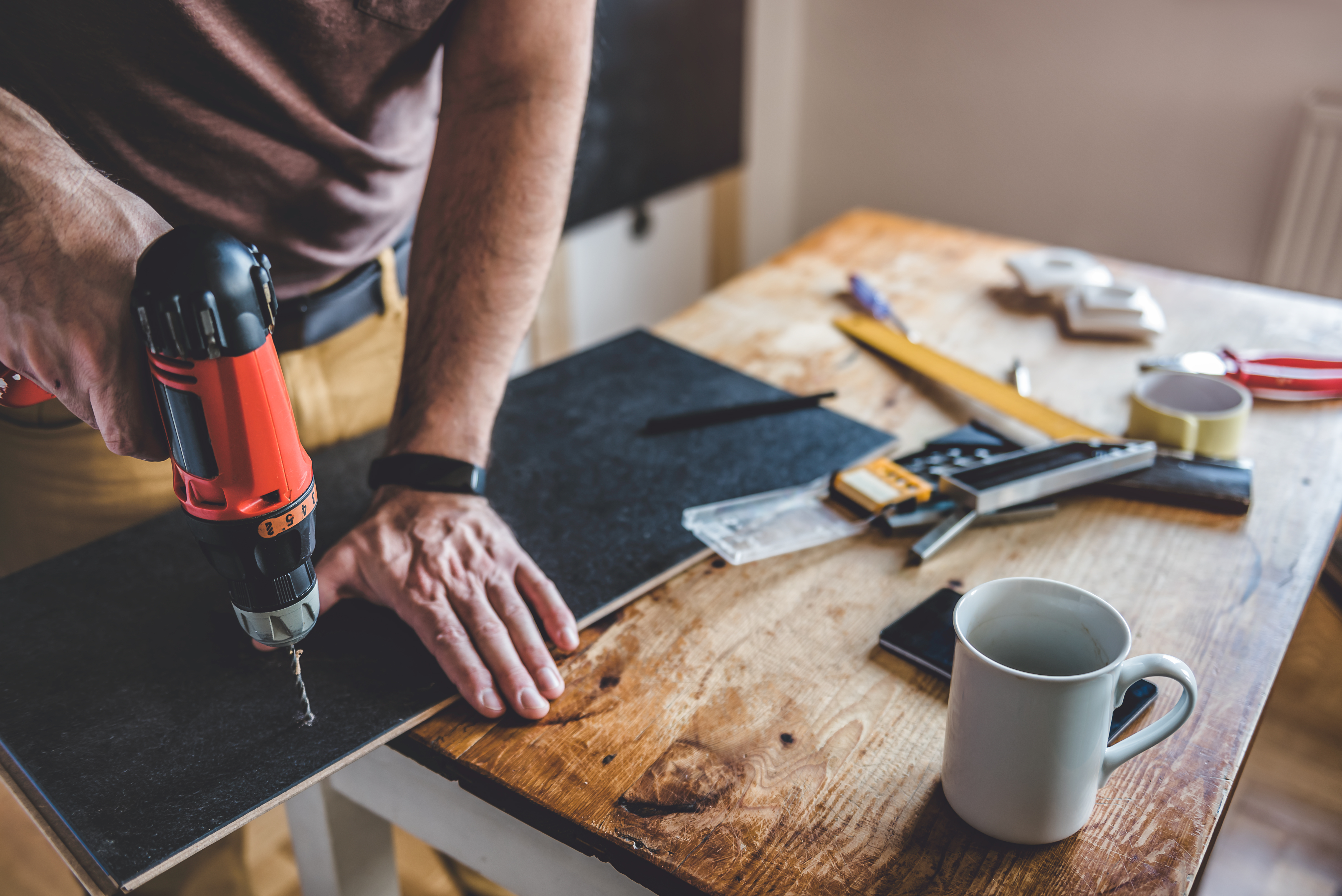 Man drilling into something on a work bench