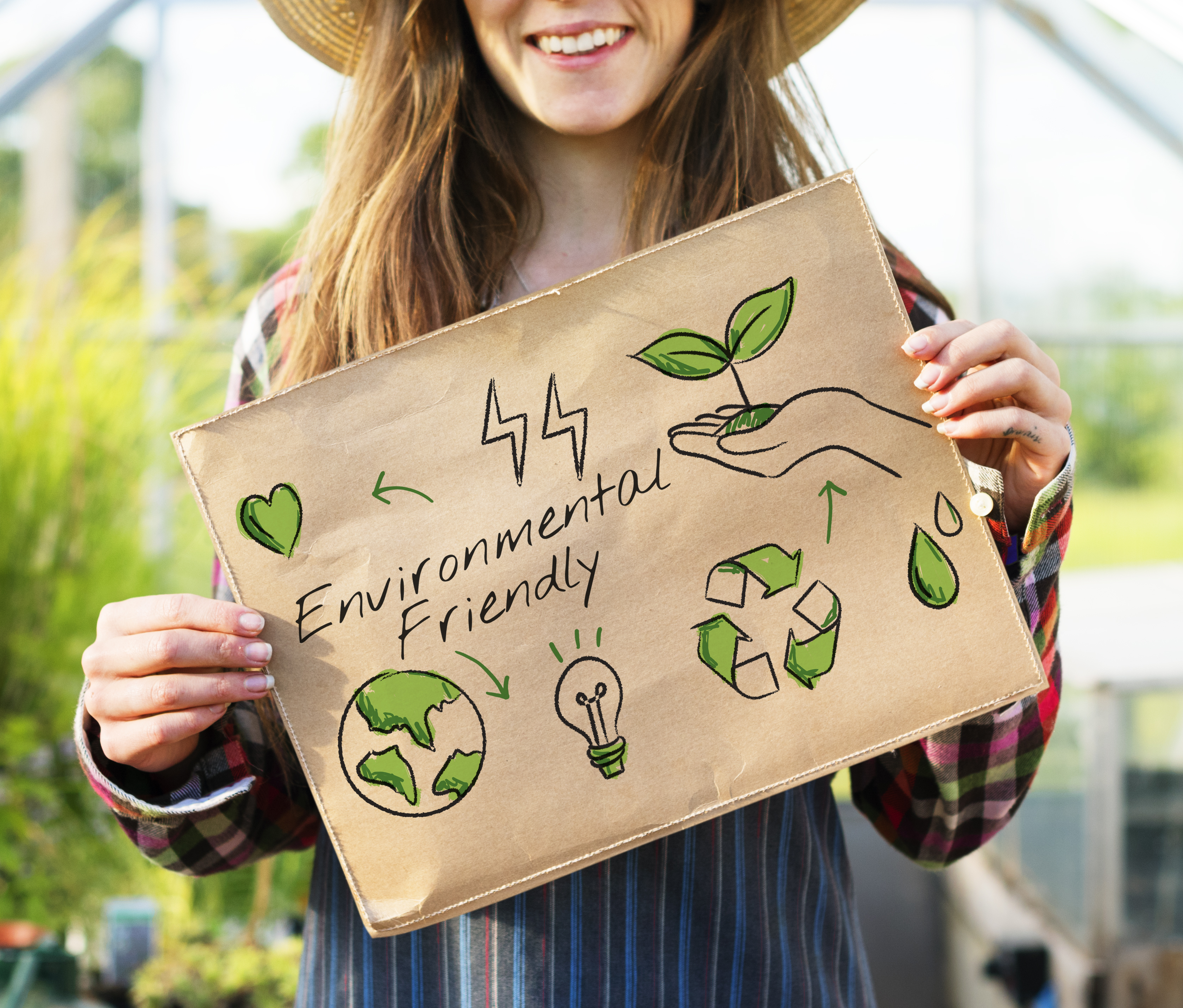 Woman holding up a sign that says environmentally friendly