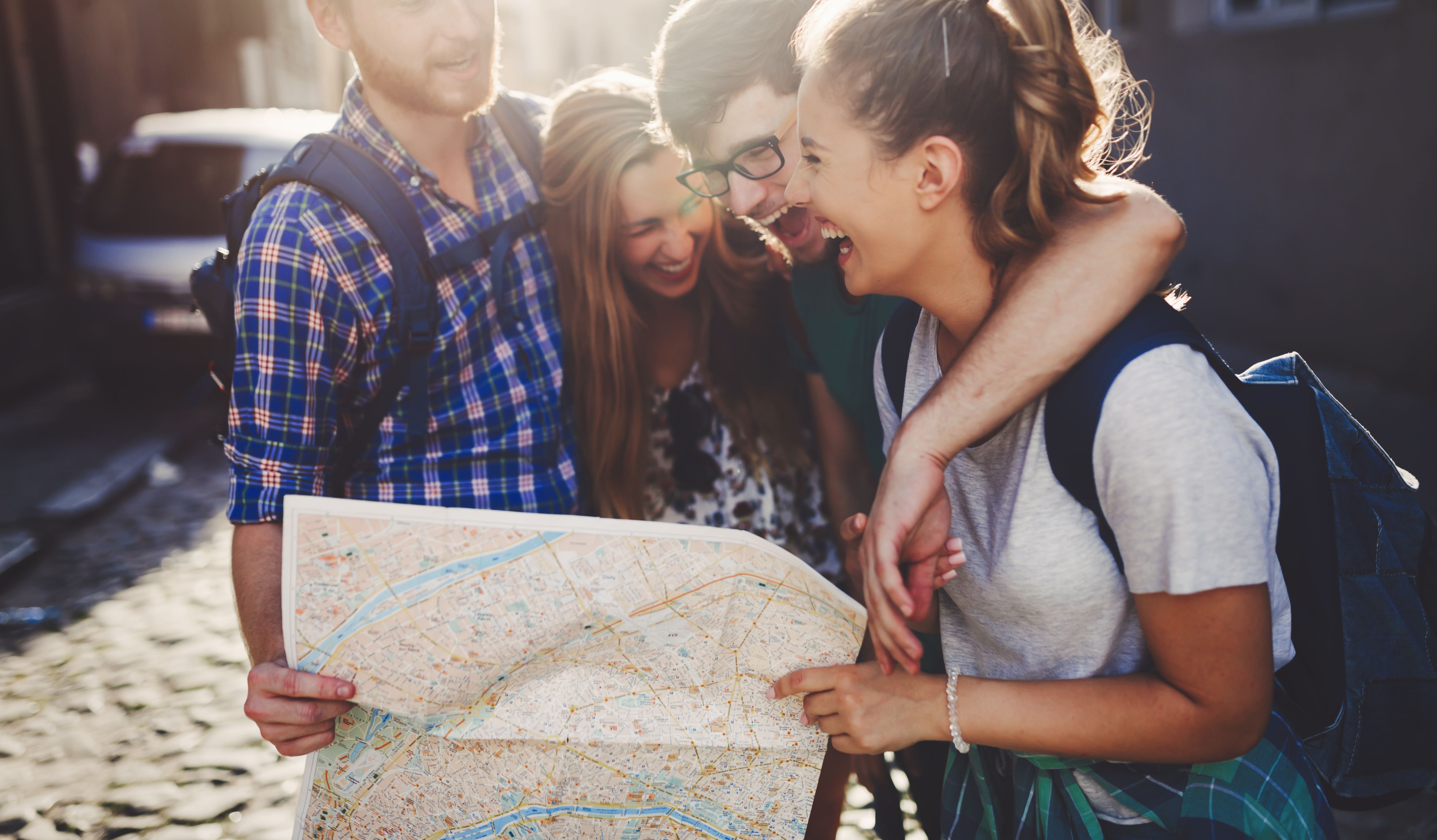 Group of people smiling outside and holding a map