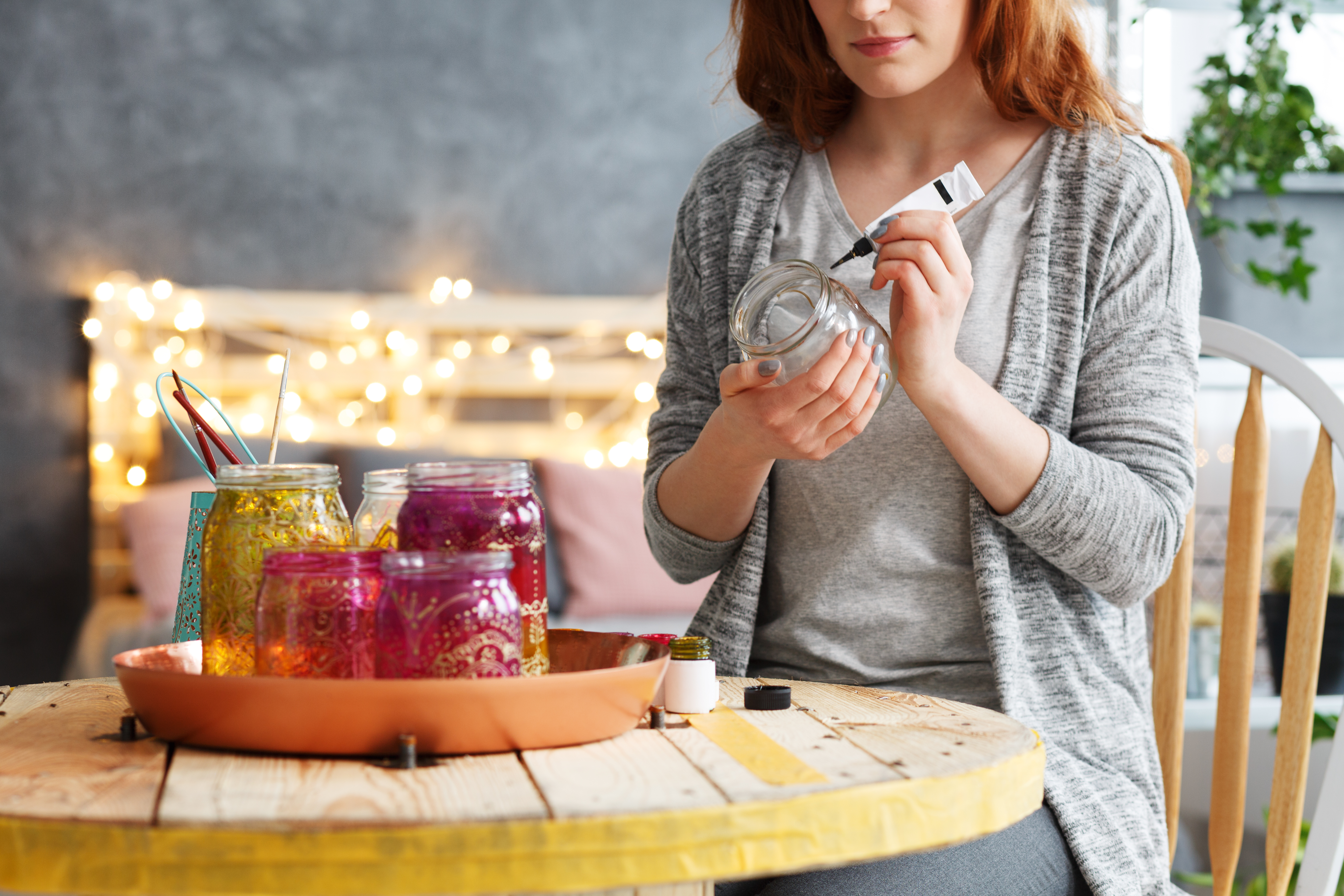 Woman with red hair painting mason jars