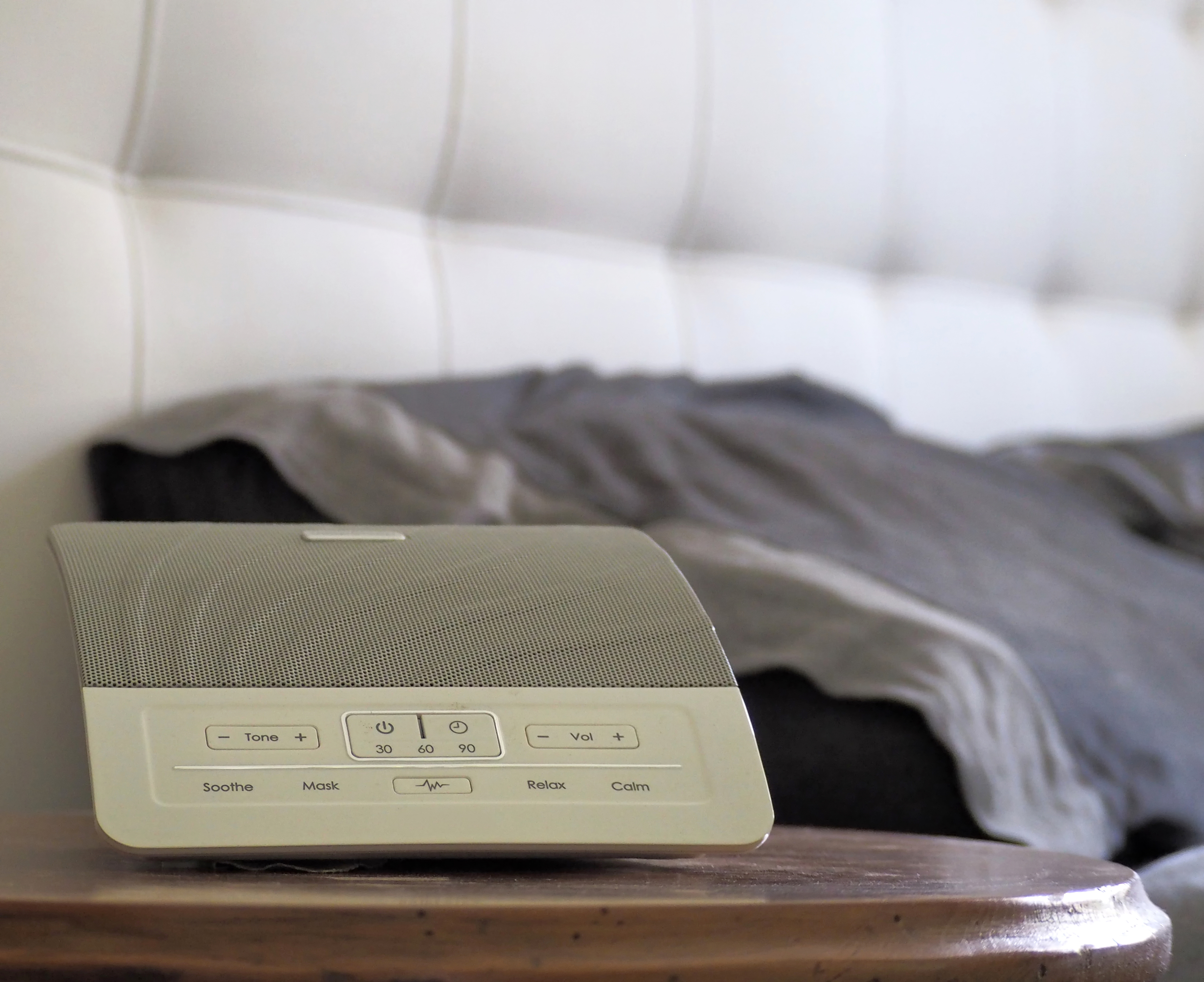 White noise machine on a bedside table