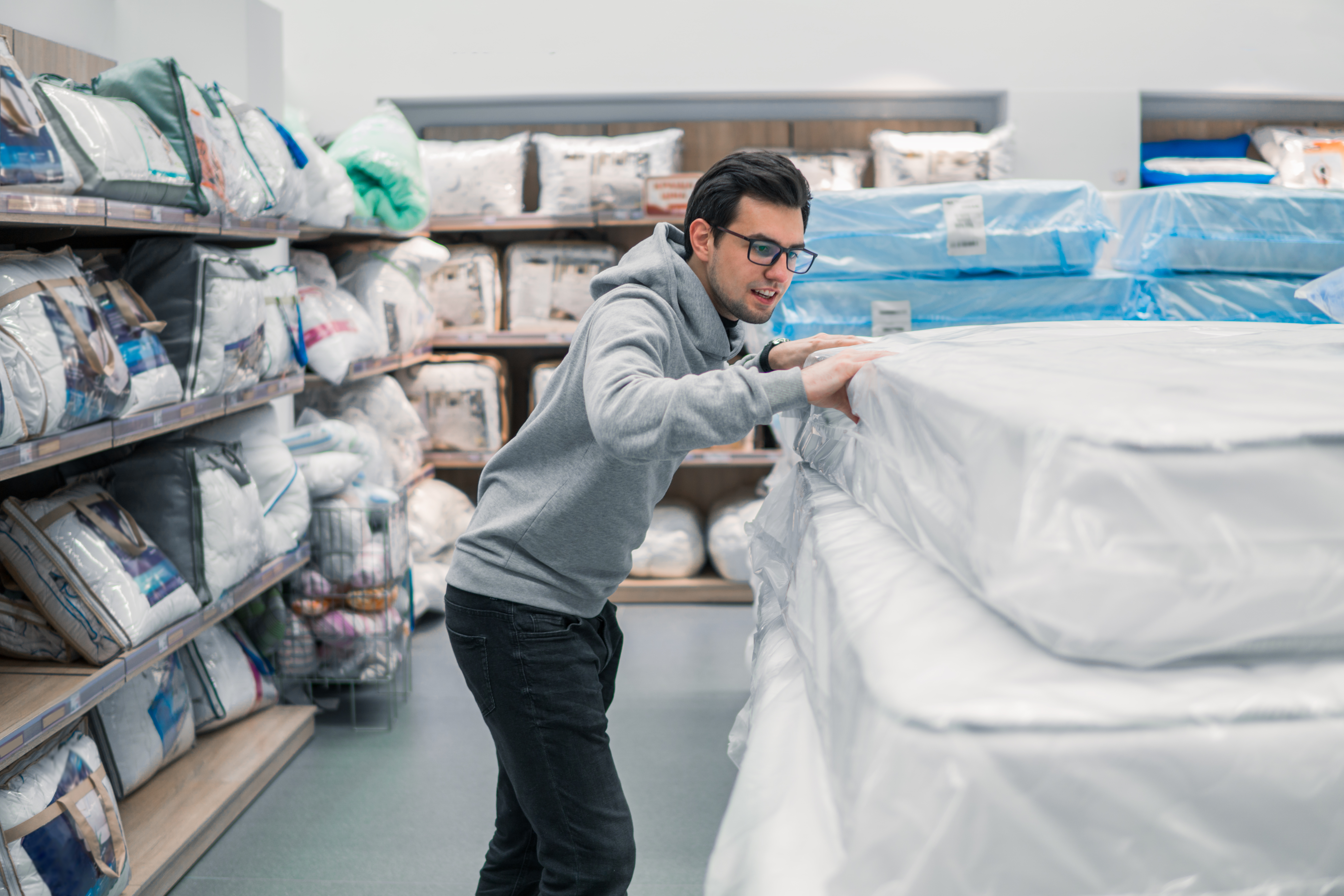 Man wearing glasses shopping for a mattress